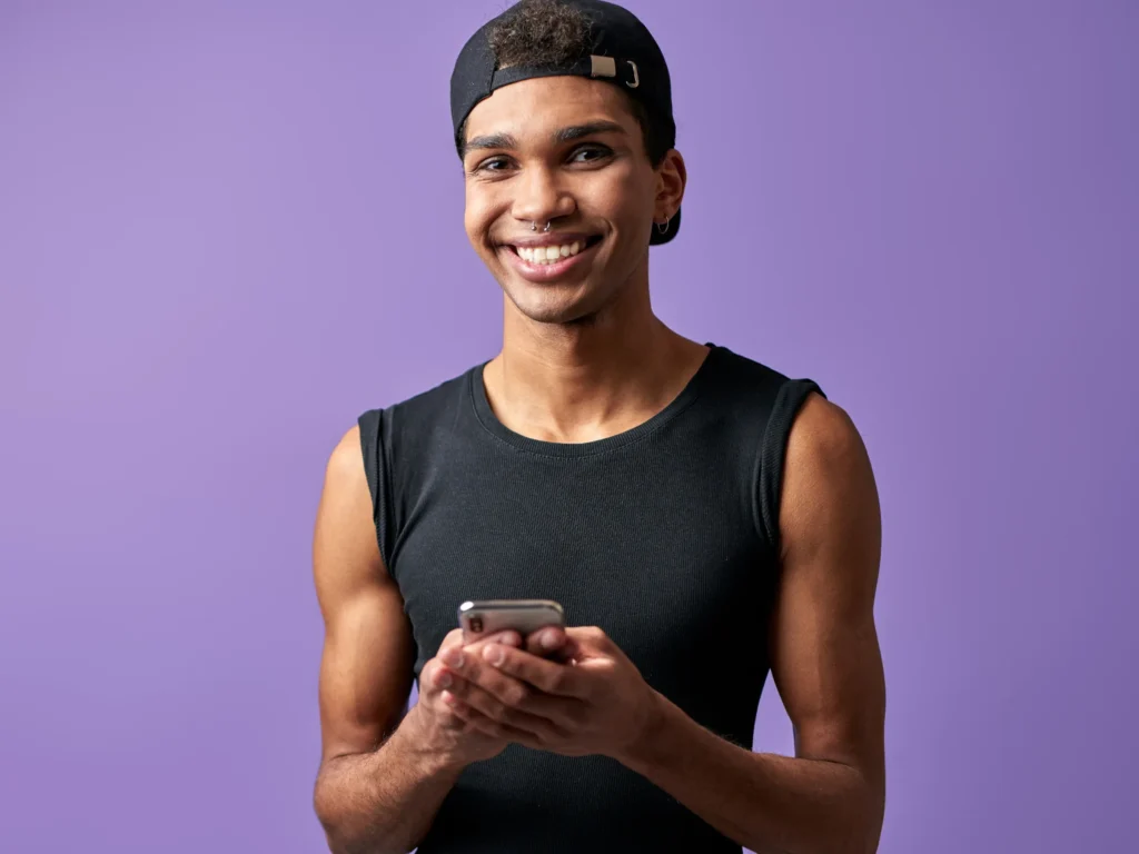 Hombre creador de OnlyFans usando el móvil con sistema de chatting profesional de agencia OFM hombres